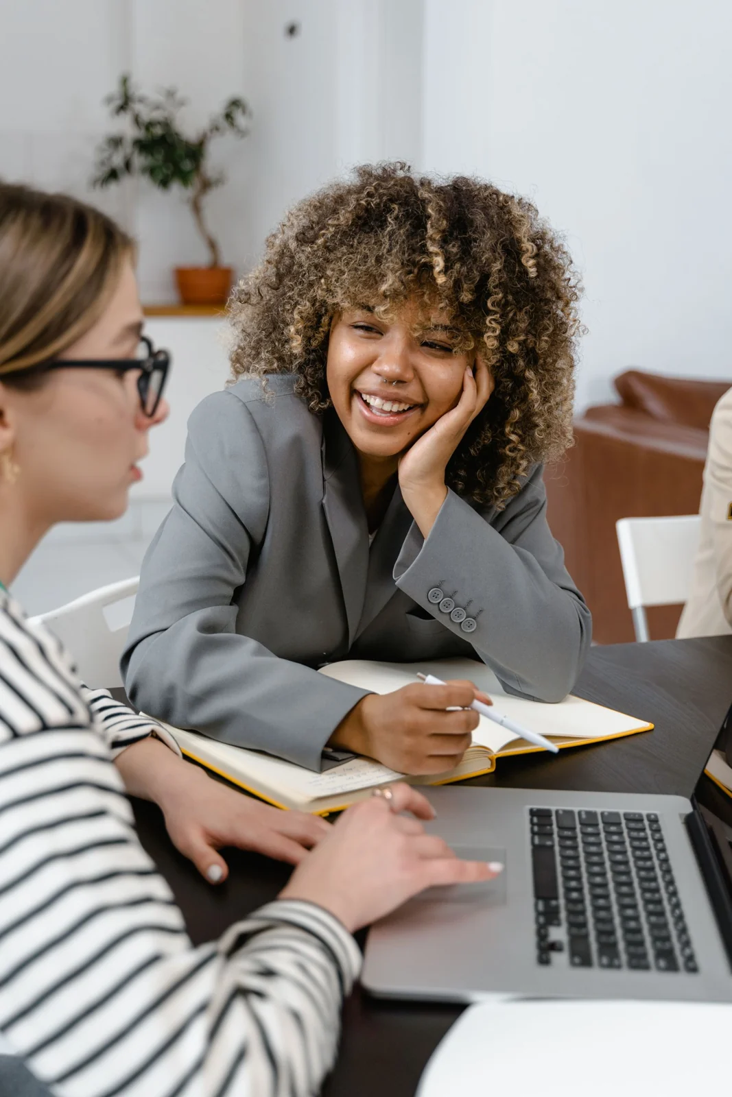 Profissional sorrindo durante uma conversa com um colega no escritório